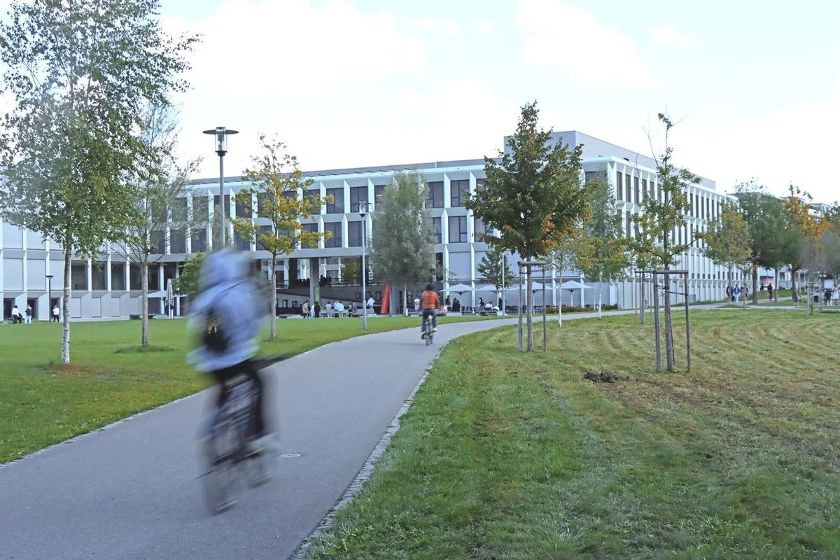 Man sieht einen verschwommenen Velofahrer, der auf einem Weg fährt.